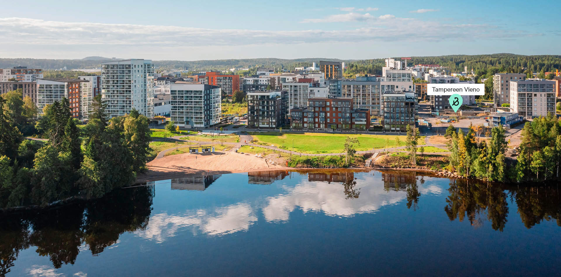 Ilmakuva Härmälänrannan kerrostaloista, rantapuistosta ja järvestä Tampereella.